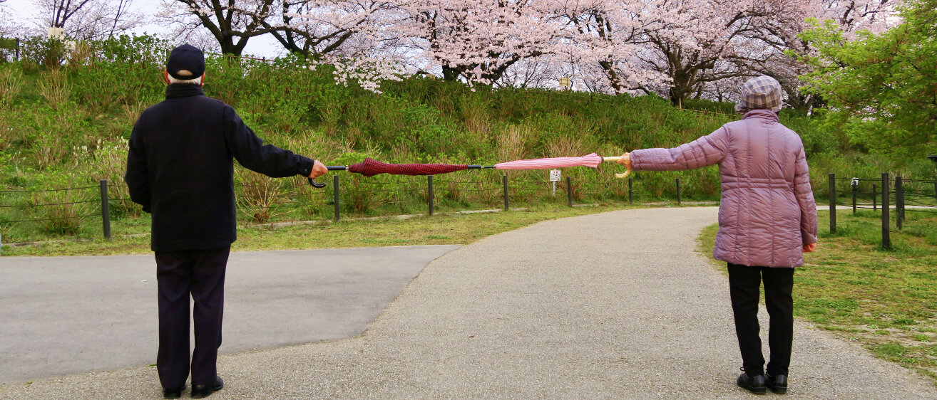 Rentnerpaar mit Regenschirmen. © Picturesque Japan / iStock / Getty Images Plus