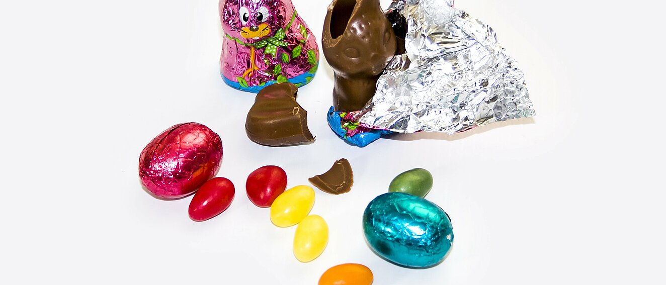 Es angebissener, halb ausgepackter Schokoladenhase und weitere ostertypische Schokolade sind abgebildet.