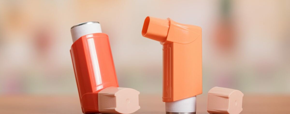 Orangene Asthma-Inhalatoren auf Tisch.