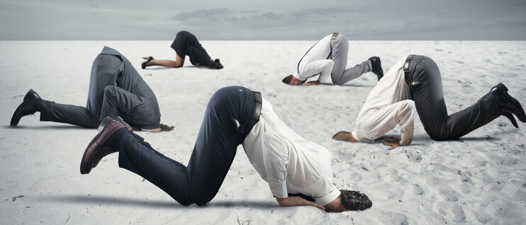 Menschen stecken Kopf in Sand