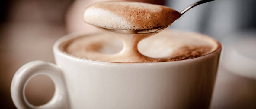 Löffel taucht in Cappucchino