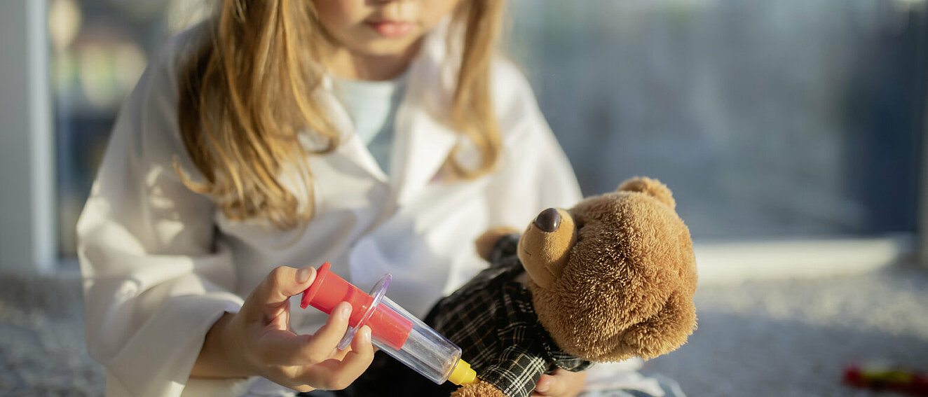 Mädchen impft Teddybär. © Alina Demidenko / iStock / Getty Images Plus