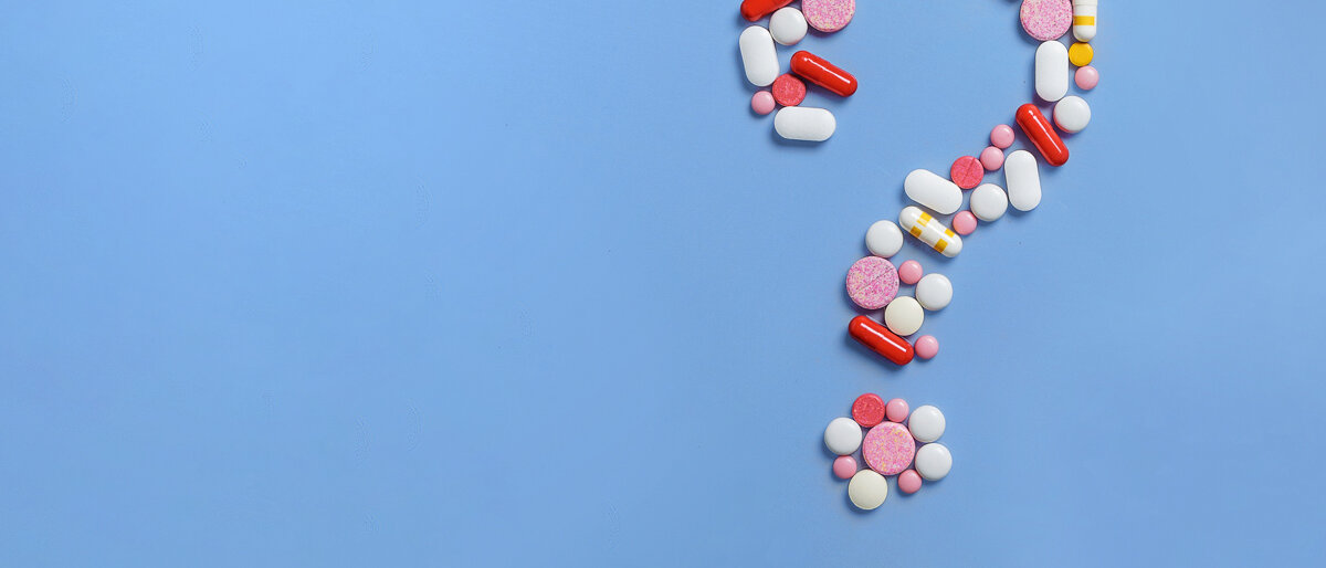 Ein Fragezeichen wurde aus Tabletten auf einen blauen Untergrund gelegt.