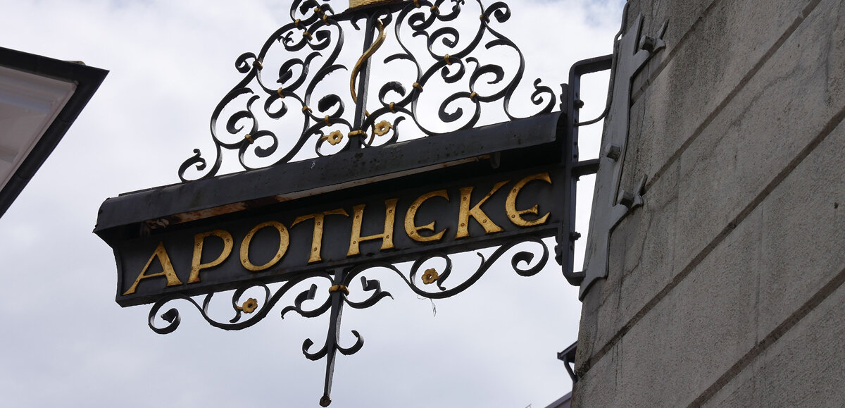 Ein altes Apothekenschild aus Messing an einer Hauswand