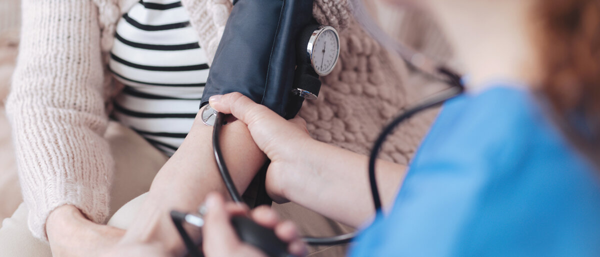 Eine medizinische Fachkraft misst den Blutdruck einer anderen Person.