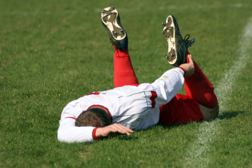 Fußballer liegt verletzt auf dem Boden. © Garnhamphotography / iStock / Getty Images